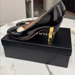 Vintage Chanel black patent leather pumps with gold heel.